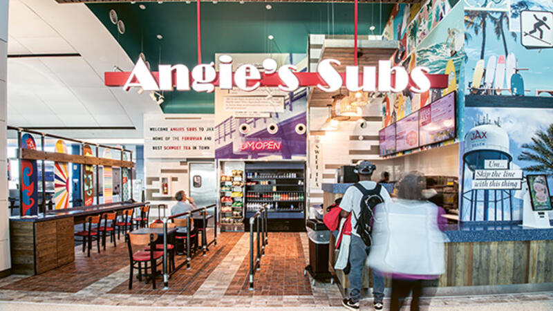 Angie's Subs restaurant with a counter and a few tables for guests to sit.