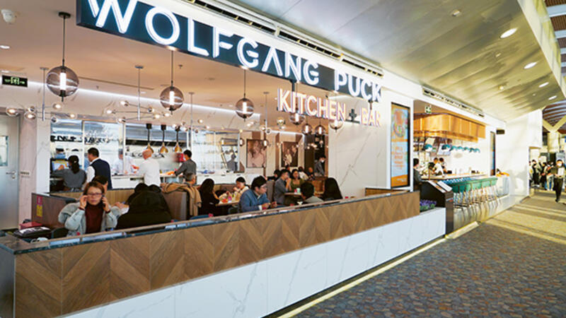 Passengers ordering at the counter or sitting and enjoying their meals.