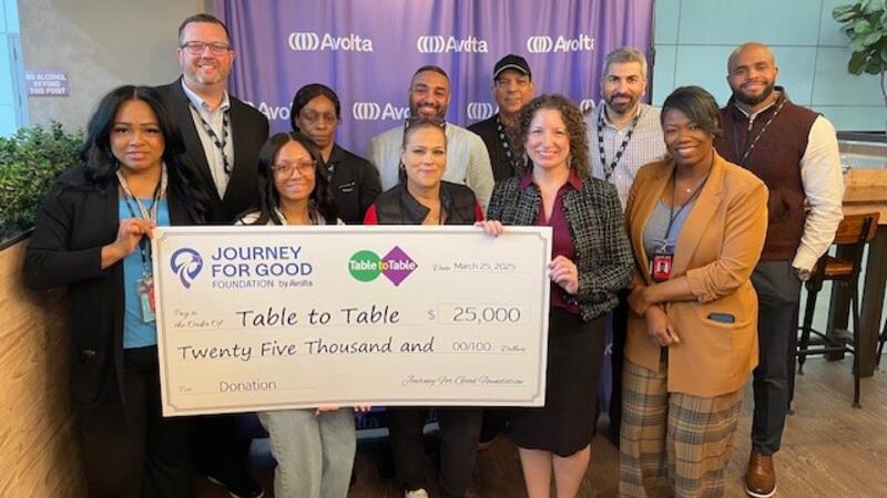 A group of people presenting a check, displaying the donation amount, to a foundation.