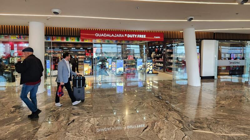 People passing by a duty free shop inside an airport