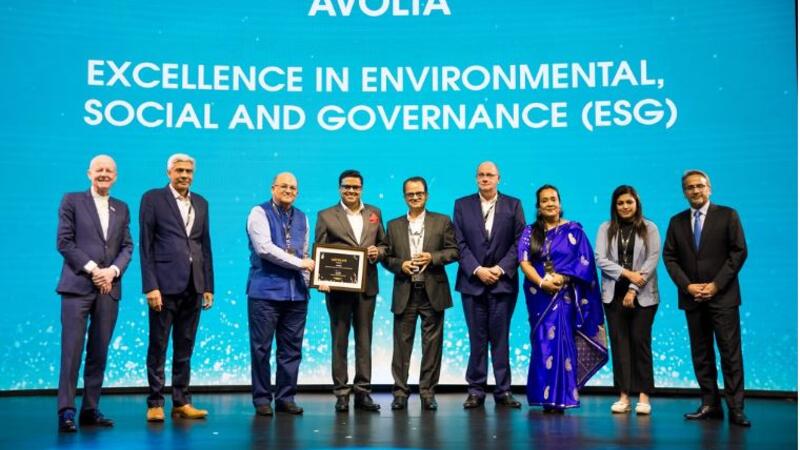 People on a stage receiving a plate for an award.