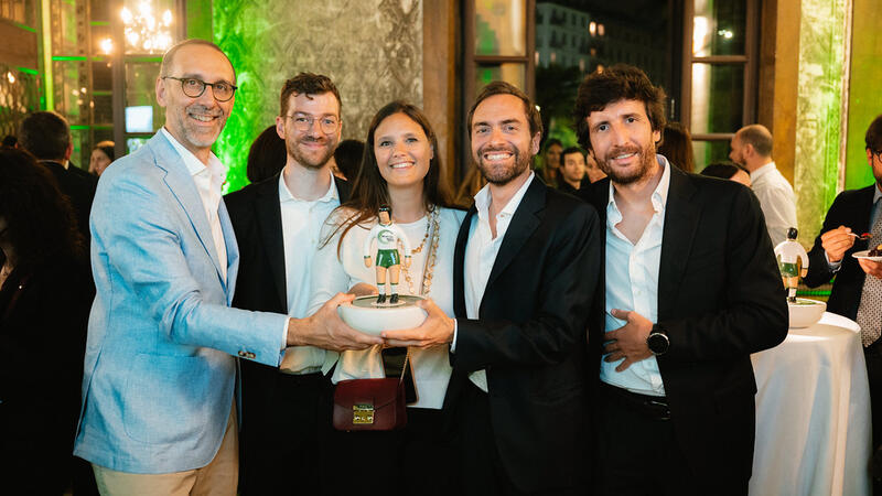 5 smiling people showing an awards they have received. 