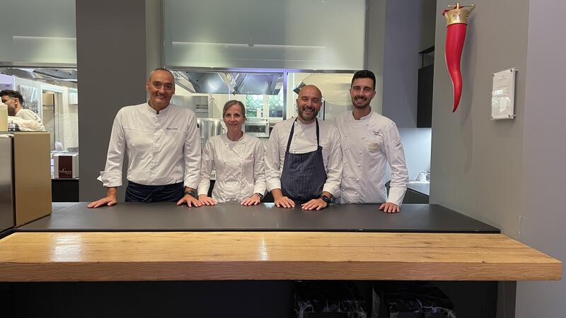 Four chef behind a counter.