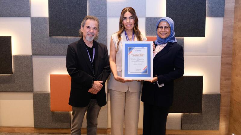 Three people receiving an award.