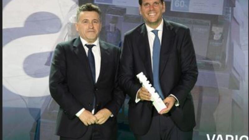 Two men holding a trophy award on a stage