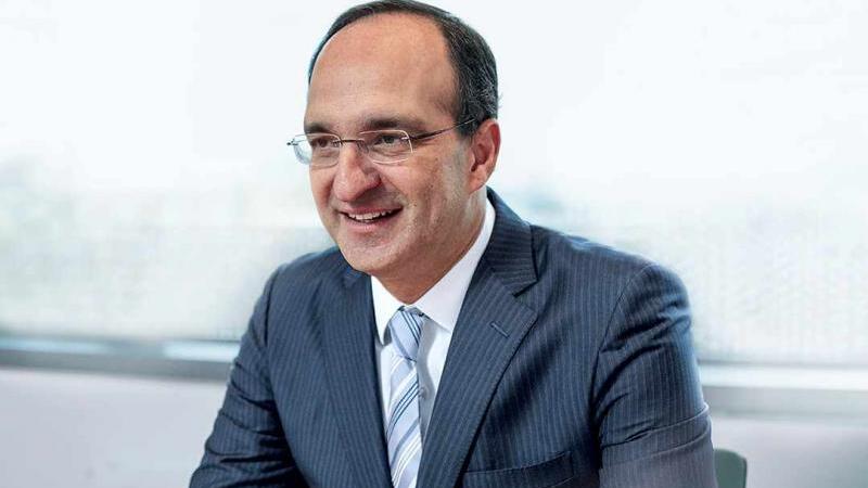 A man with glasses and blak hair wearing a suit