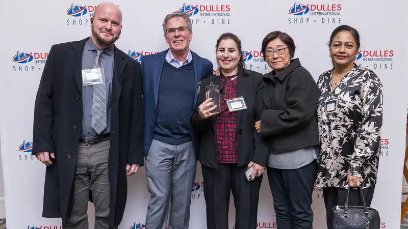 A group of people in front of a wallpaper for a prize