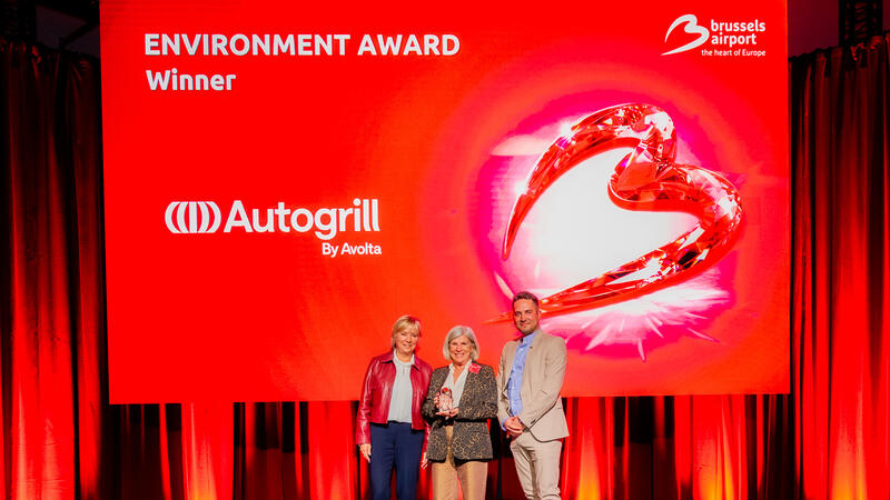 3 people on a stage receiving an award