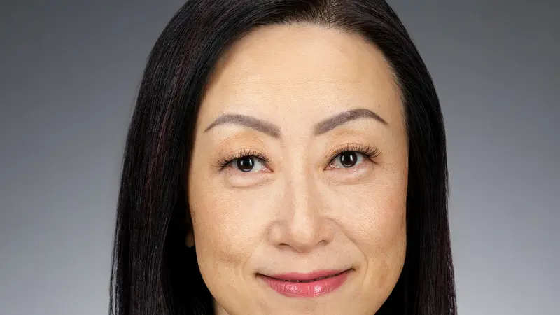 An asian woman with dark hair and a black suit