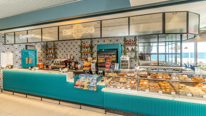 A bar with a turquoise base and food display