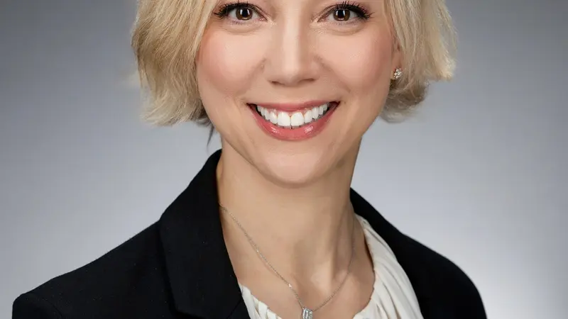 A blonde woman with short hair wearing a suit