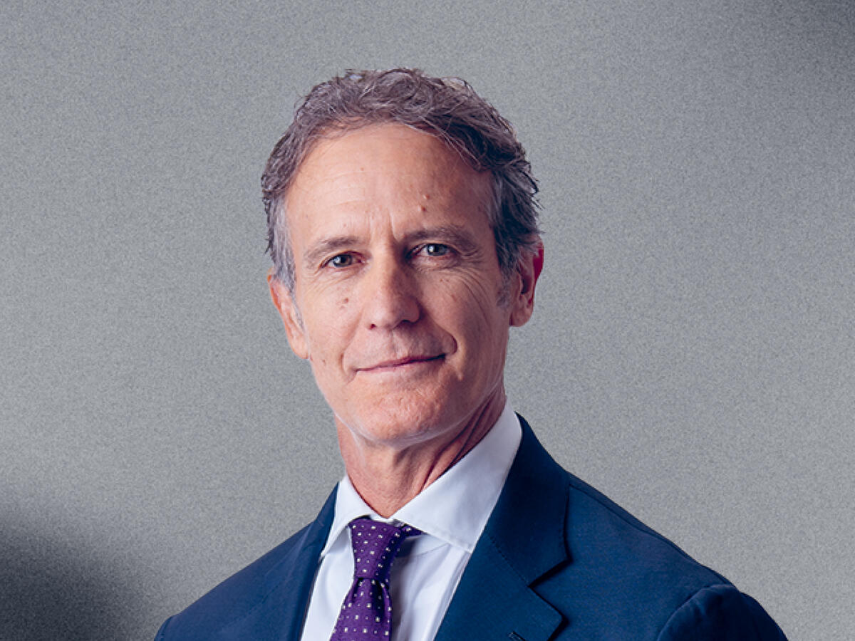 Portrait of Alessandro Benetton, a man in his 50s in a blue suit and a violet tie