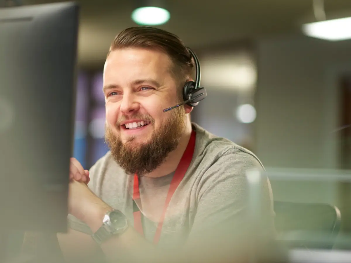 A guy in front a laptop with headphones.