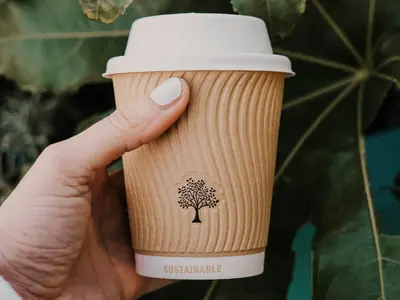 coffee cup held up by a hand