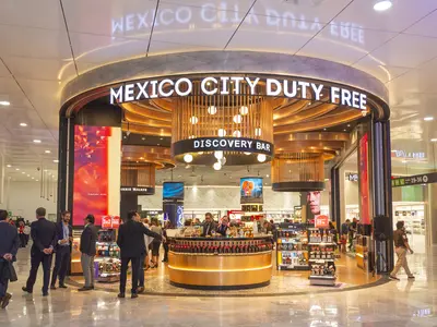 Some people entering the Mexico City Duty Free's entrance featuring a counter.