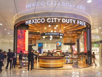 Some people entering the Mexico City Duty Free's entrance featuring a counter.