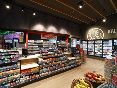 Shelves and refrigerated units showcasing items available for purchase in the market of a store on the motorway..