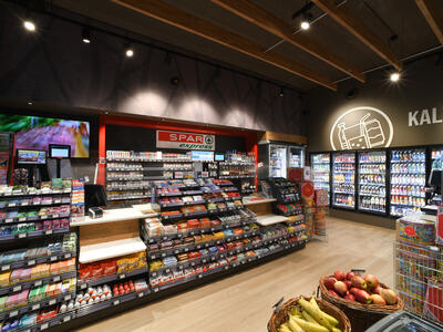 Shelves and refrigerated units showcasing items available for purchase in the market of a store on the motorway..