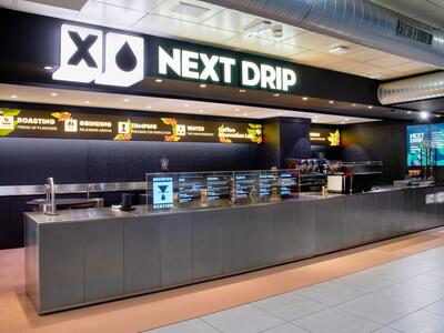 Next Drip store counter featuring descriptive panels explaining coffee roasts and treatment processes.