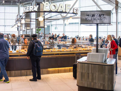 People standing in front of a counter of a store inside an airport