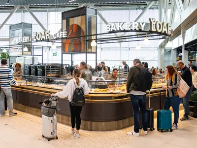 People standing in front of a counter of a store inside the airport.