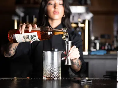 A bramaid pouring a drink