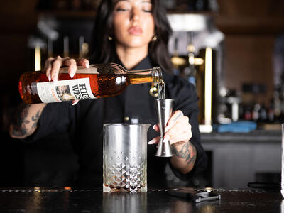 A bramaid pouring a drink