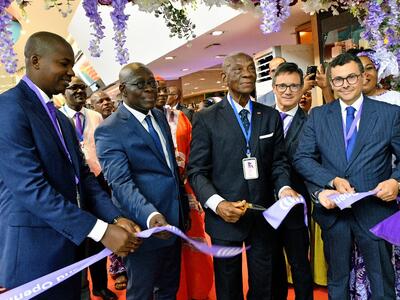 A group of people cutting the ribbon for the opening of a duty free
