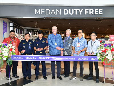 A group of people cutting a ribbon for the opening of a store