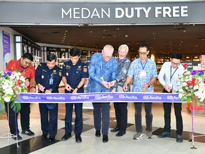 A group of people cutting the ribbon at the opening of a store 