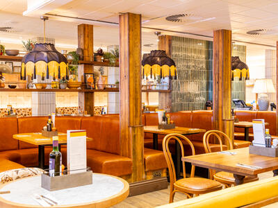 Tables, lamps and chairs inside a restaurant