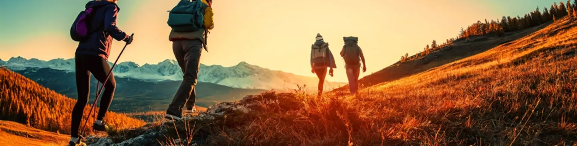 Hikers walking over mountain with sunset