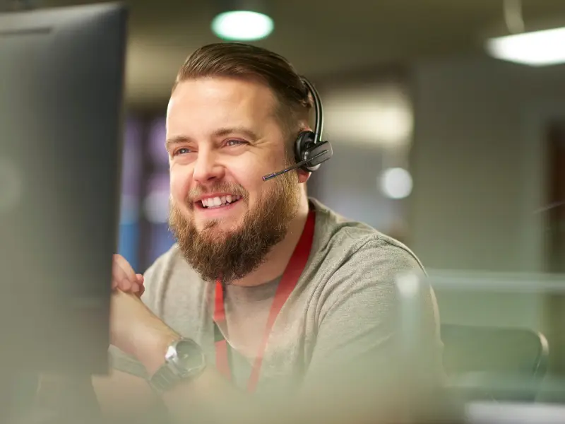 A guy in front a laptop with headphones.