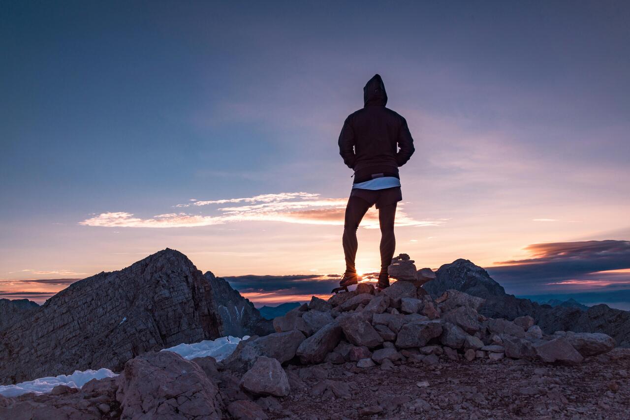 Man on mountain top looking at the view