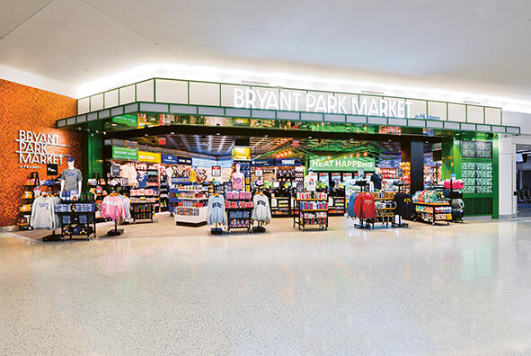 A convenience store with shelves of NY shirts and drinks and snacks