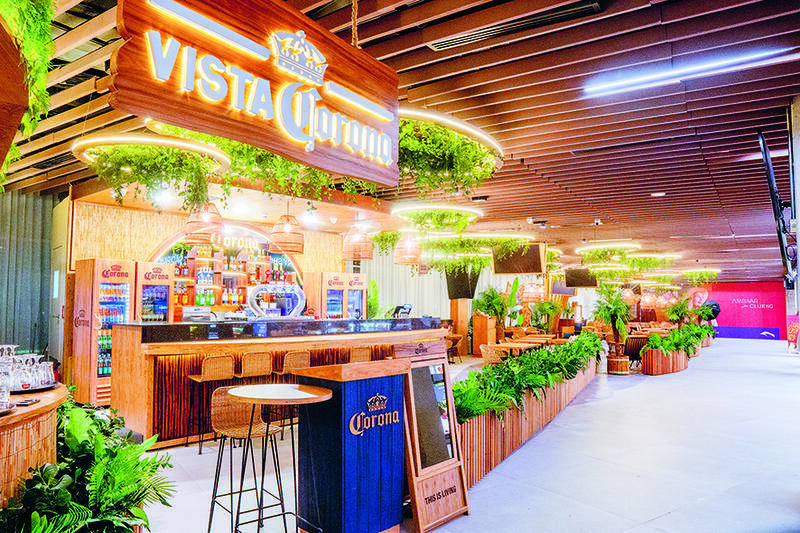 The counter of a bar with plants and wood stools